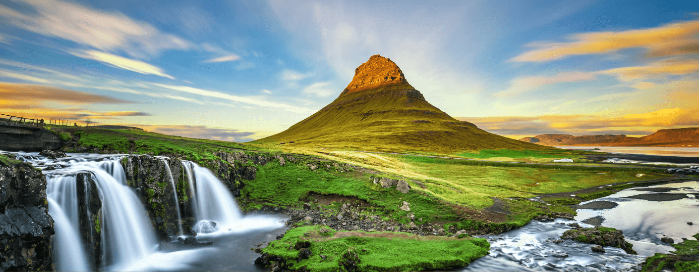 Landschap in IJsland, in het midden een berg met watervallen en een kleurrijke lucht met wolken