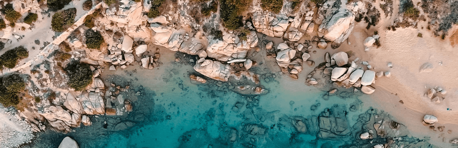 Fel blauw water en klei achtige rotsen die de kustlijn van Sardinië vormen