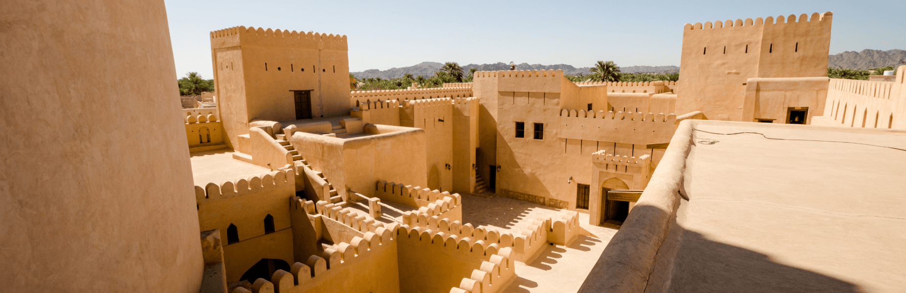 oude kasbah in oman met palmbomen eromheen