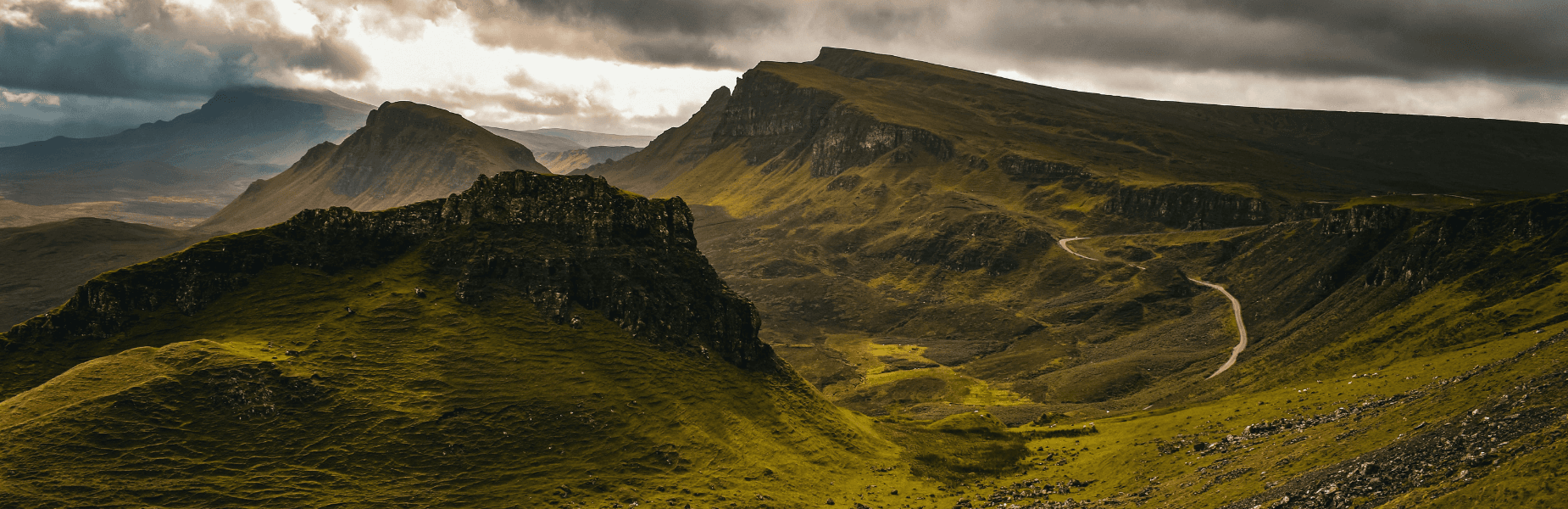 Header ultieme roadtrip Schotland, uitzicht op een vallei in Skye met op de achtergrond verschillende bergen