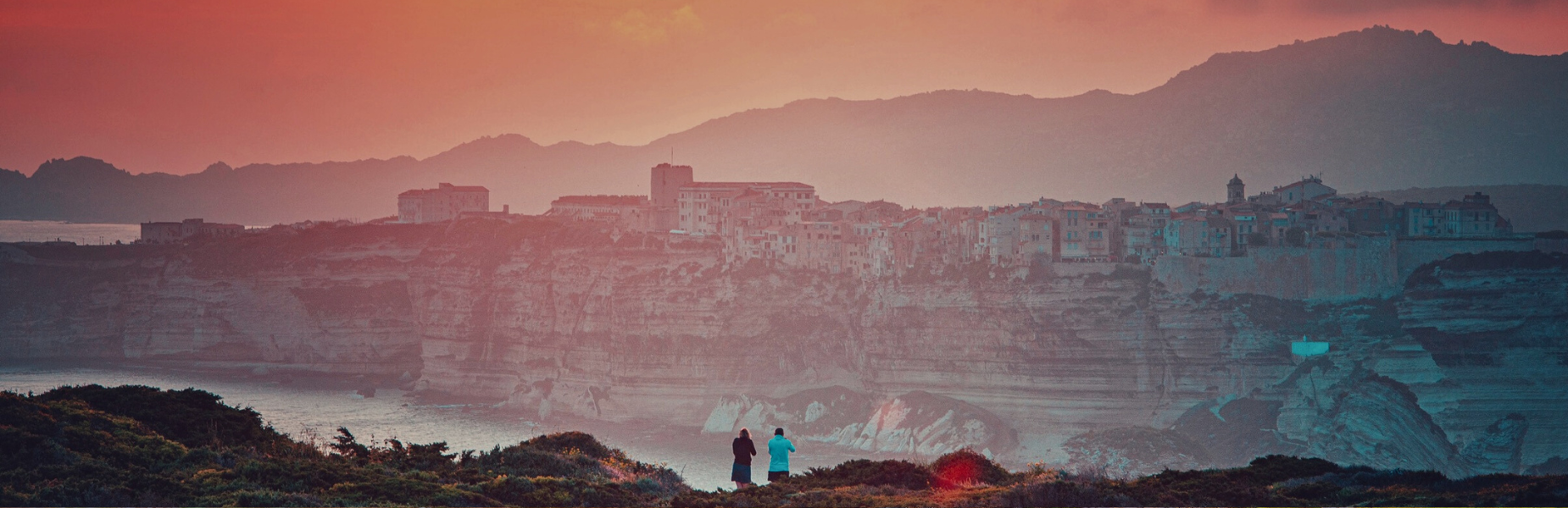 Twee vrouwen staan bij zonsondergang op een uitkijkpunt bij Bastia