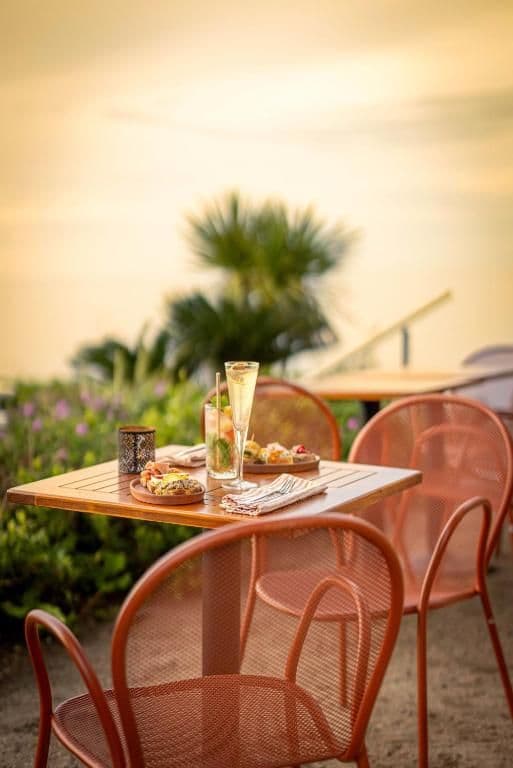 Terras in Calvi met zonsondergang en cocktails en hapjes op tafel