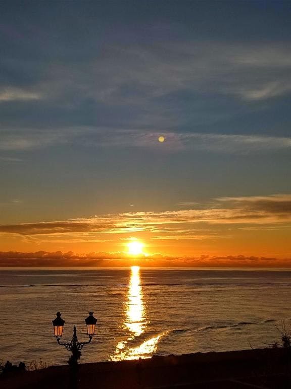 De kust van Bastia tijdens zonsondergang met een lantaarn in beeld