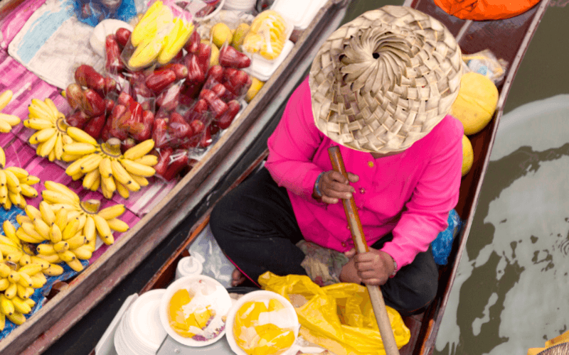 floating market bangkok met vrouw met verse vruchten