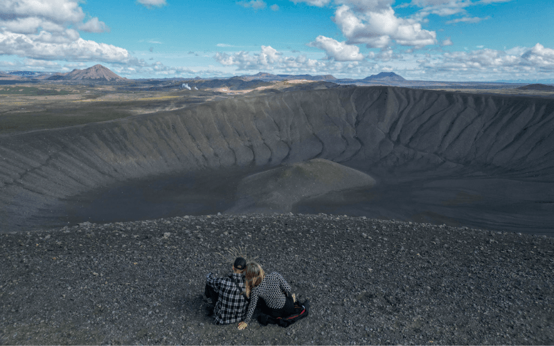 2 reizigers uitkijkende over het krater landschap in IJsland
