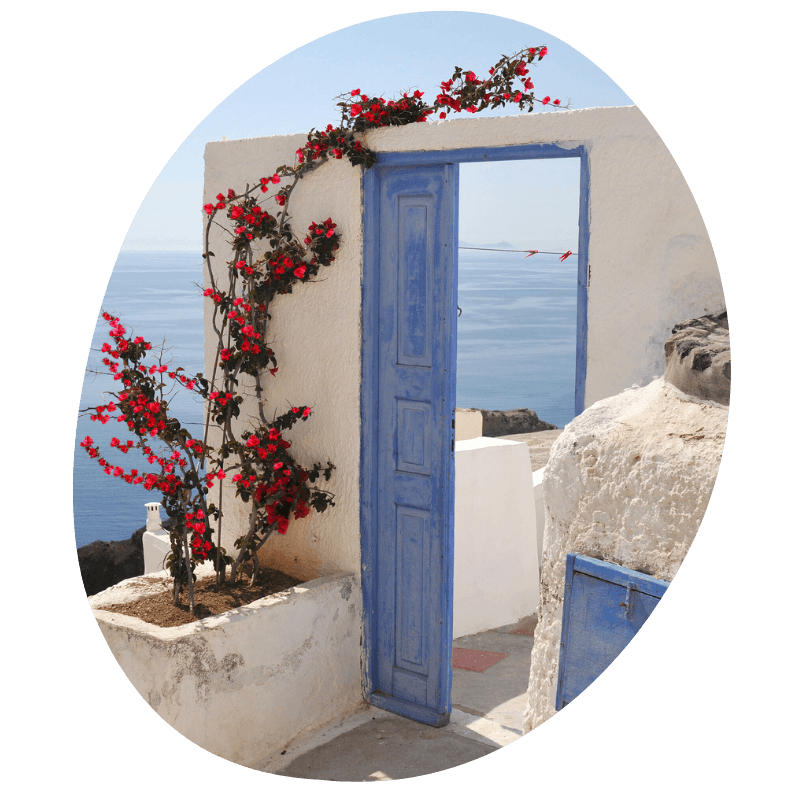 doorkijkje bij wit huisje met blauw deurtje op santorini