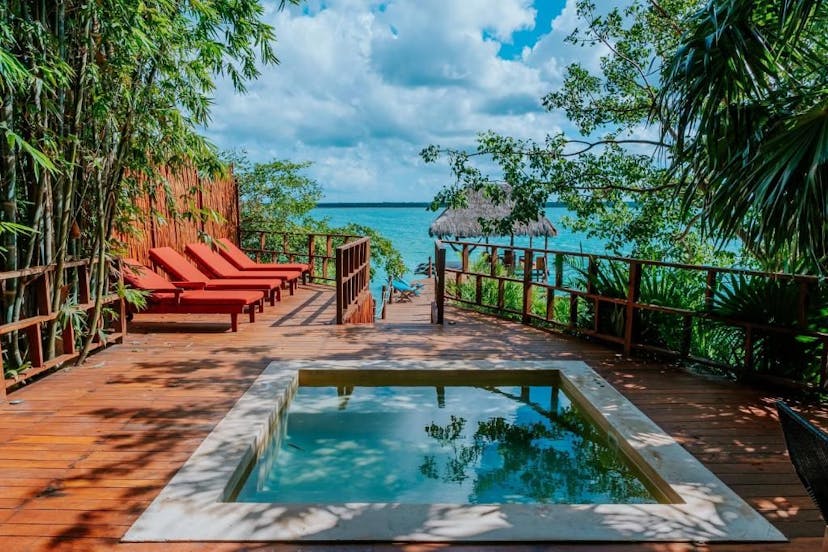 Hotel zwembad aan het bacalar meer met ligbedjes