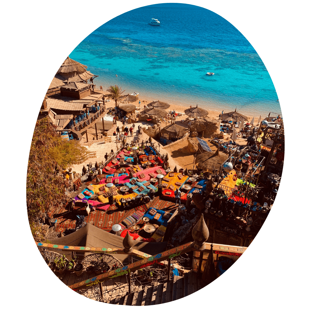 Prachtig helderblauw water aan een druk strandje met veel kleurtjes