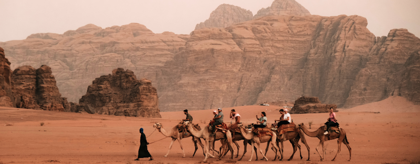foto van kameelrit groep van 6 kamelen met rotsen op de achtergrond