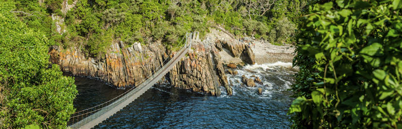 Hangbrug tussen twee rotsen aan de kust