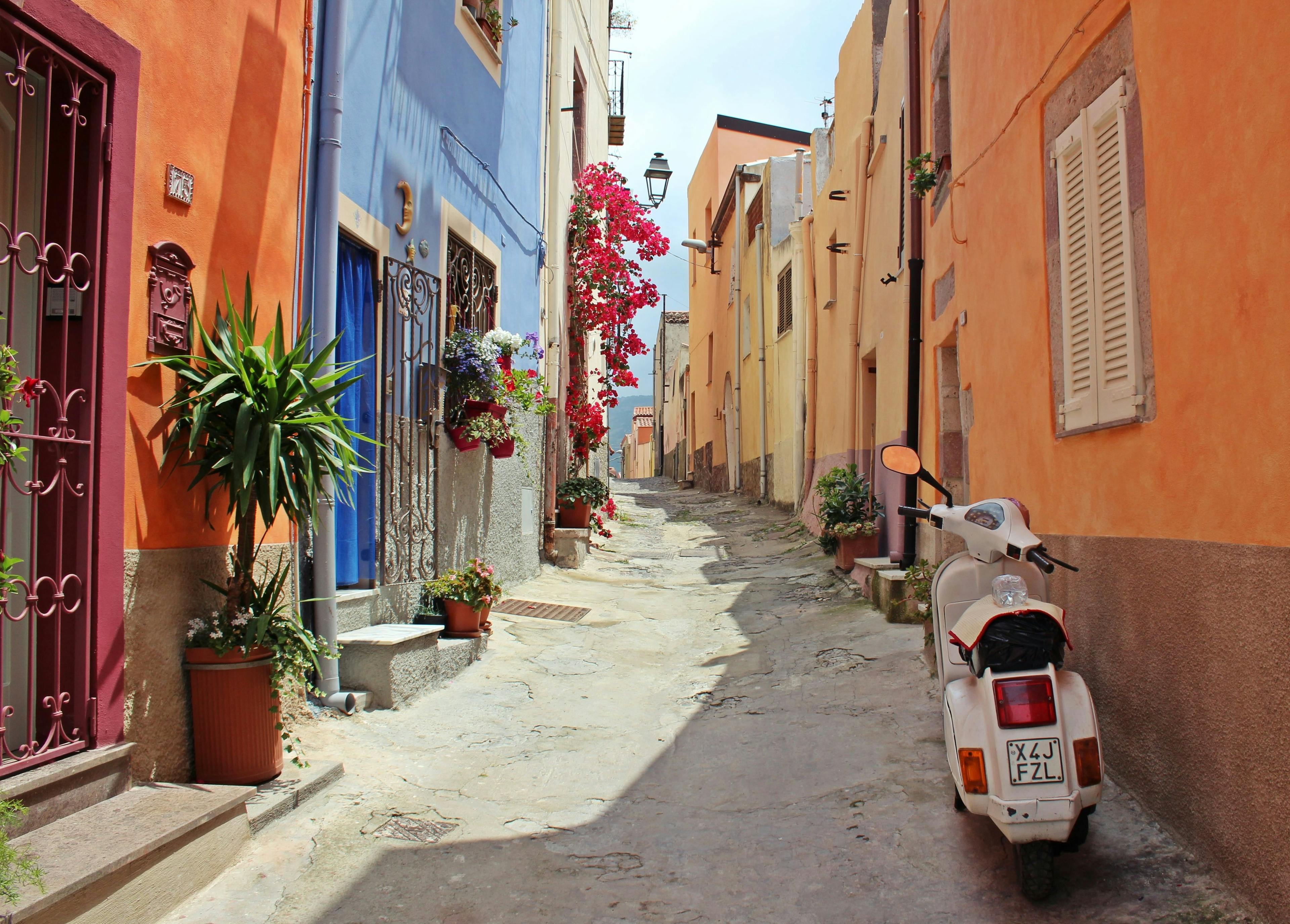 Kleurrijke straatje in Italie met scooter en bloemen